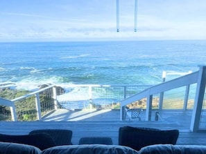 A deck with a view of the ocean, a railing, and a staircase leading to a higher level. - Oceanfront home with fireplace & private hot tub - close to town (Gualala)
