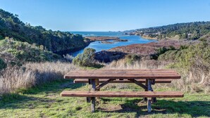 Een picknicktafel in een natuurlijke omgeving met uitzicht op een kustlandschap.
