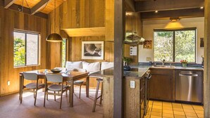 A wooden interior with a dining area, kitchen, and large windows. - Rare Ocean Views & Sea Ranch Magic on the Mendocino Coast (Sea Ranch)