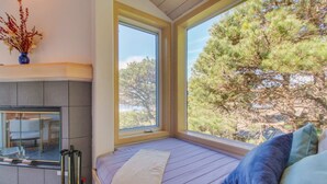 Ein Zimmer mit Bett, Fenster und Blick auf Bäume.