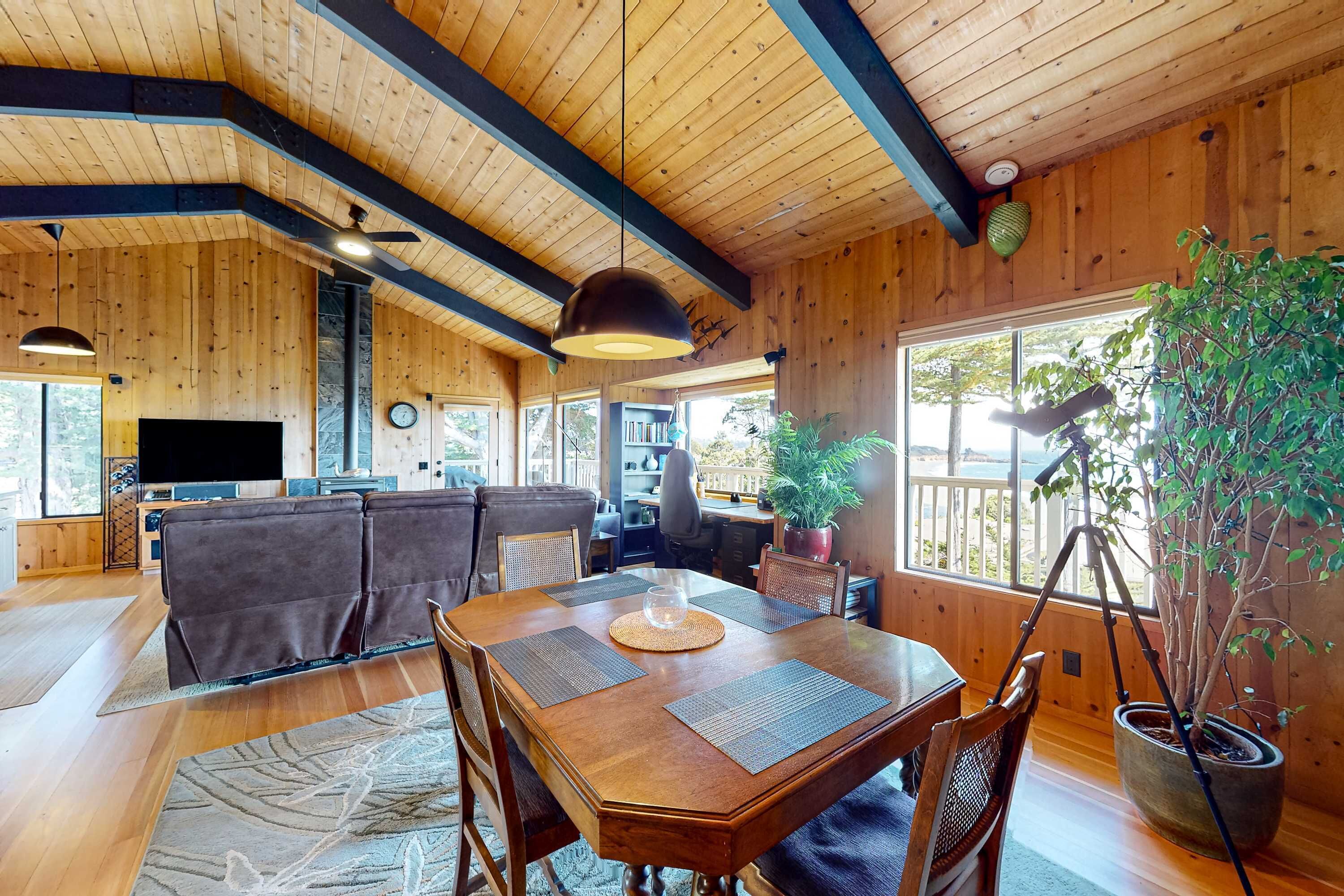 Un intérieur en bois comprenant une table à manger, des chaises, un canapé et un téléviseur.
