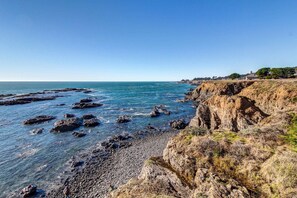 A coastal landscape with rocky cliffs and a clear blue sky. - Ocean-view home with private hot tub near Pebble Beach (Sea Ranch)
