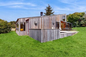 A modern house with a large glass window, a chimney, and a wooden exterior. - Sea Ranch 2BR Don Jacobs-designed home with hot tub near Shell Beach (Sea Ranch)