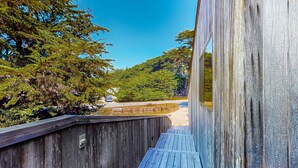 Une terrasse en bois offrant une vue sur une forêt et une route.