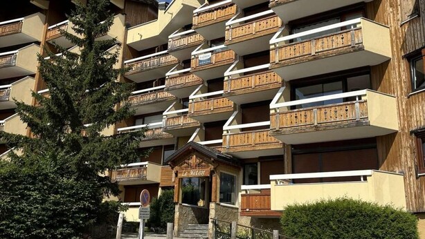 Ett hotell med flera våningar, träbalkonger, en skylt med texten ”Le Meteor” och en grusuppfart.