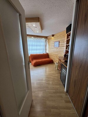 Ein gemütlicher Raum mit einem Bett, einem kleinen Tisch und einer Küchenzeile.