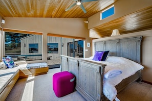 A bedroom with a large bed, a wooden headboard, a window, and a view of the outdoors. - Coastal Luxury: Chef Kitchen, Ocean Views, Hot Tub (Sea Ranch)