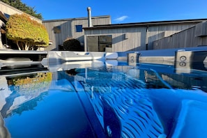 A modern building with a swimming pool, a covered patio, and a chimney. - Sunsets over the ocean, waves, whales, serenity, luxury on the bluff (Sea Ranch)