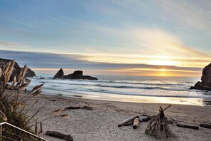 Ein Strand mit Felsen, Sonnenuntergang und blauem Himmel.
