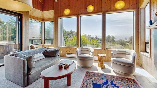A wooden interior with a sofa, armchair, and a coffee table. - Sea Ranch 2BR ocean-view home with private hot tub & courtyard (Sea Ranch)