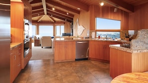 Una cocina amplia con armarios de madera, encimera de granito y vistas al paisaje.