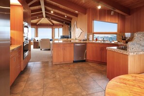 Eine geräumige Küche mit Holzschränken, einer Granit-Arbeitsplatte und Blick auf die Landschaft.