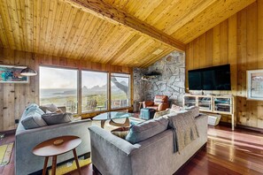 Un intérieur en bois avec un canapé, un téléviseur et un mur en pierre.