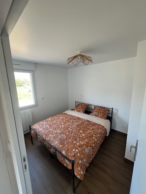 A bedroom with a bed, a window, and a ceiling fan.