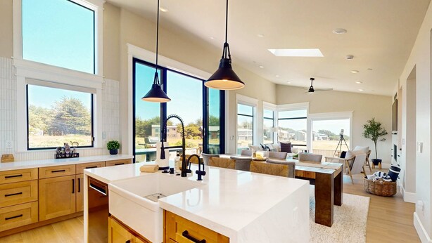 A modern kitchen with a large island, wooden cabinets, and pendant lighting. - Luxe newly built Sea Ranch home with private hot tub & ocean views (Sea Ranch)