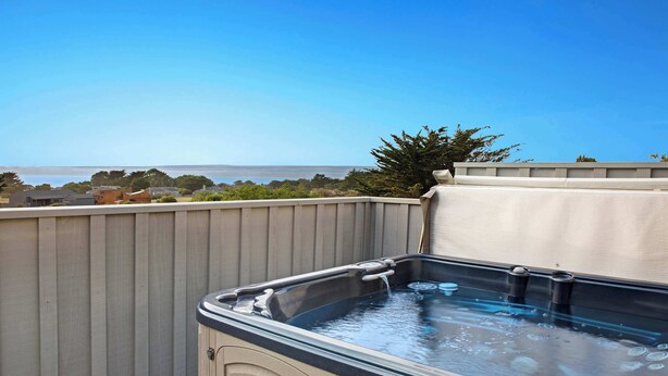 A hot tub on an outdoor deck with a view of the ocean. - Sea Ranch 2BR ocean-view home with private hot tub & fireplace (Sea Ranch)