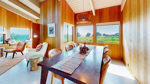 A dining area with a long table, chairs, and a view of the outdoors. - Sea Ranch 3BR oceanfront home near Shell Beach & Bluff Trail (Sea Ranch)