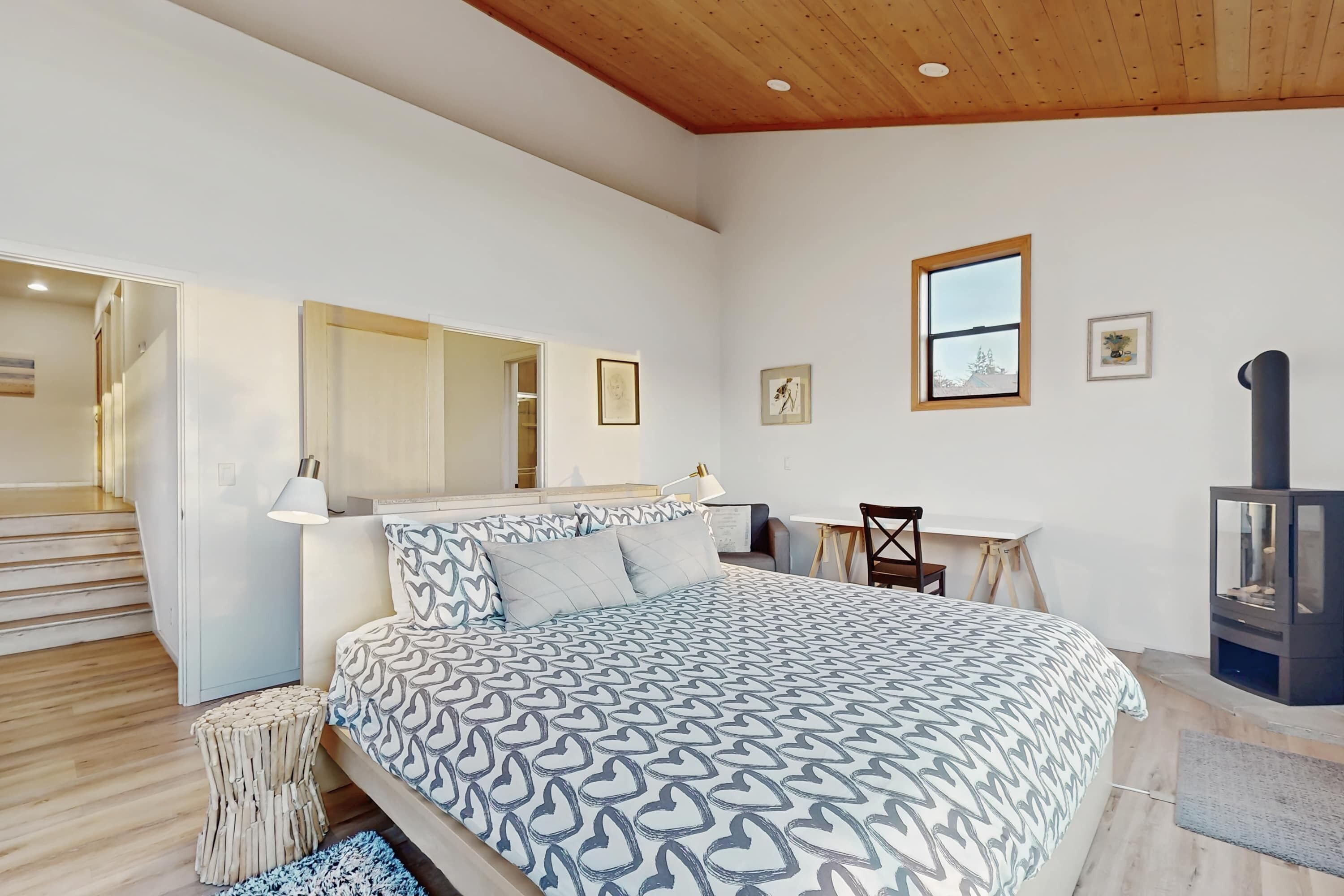 Une chambre à coucher avec un lit, une table de chevet, une lampe et une cheminée.