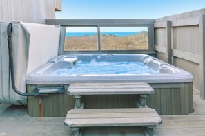 A hot tub with a view of the beach, a wooden deck, and a covered seating area. - Sea Ranch 3BR dog-friendly home with cove views & private hot tub (Sea Ranch)