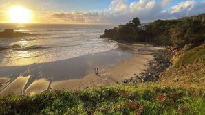 A coastal landscape with a beach, ocean waves, and a sunset. - Gualala 3BR updated coastal home with ocean views & private deck (Gualala)