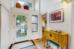A hallway with a wooden bench, a yellow dresser, and a framed artwork on the wall. - Sea Ranch 2BR ocean-view home with hot tub near Shell Beach (Sea Ranch)