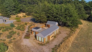 Een modern huis met een groot terras, omgeven door dicht bos.