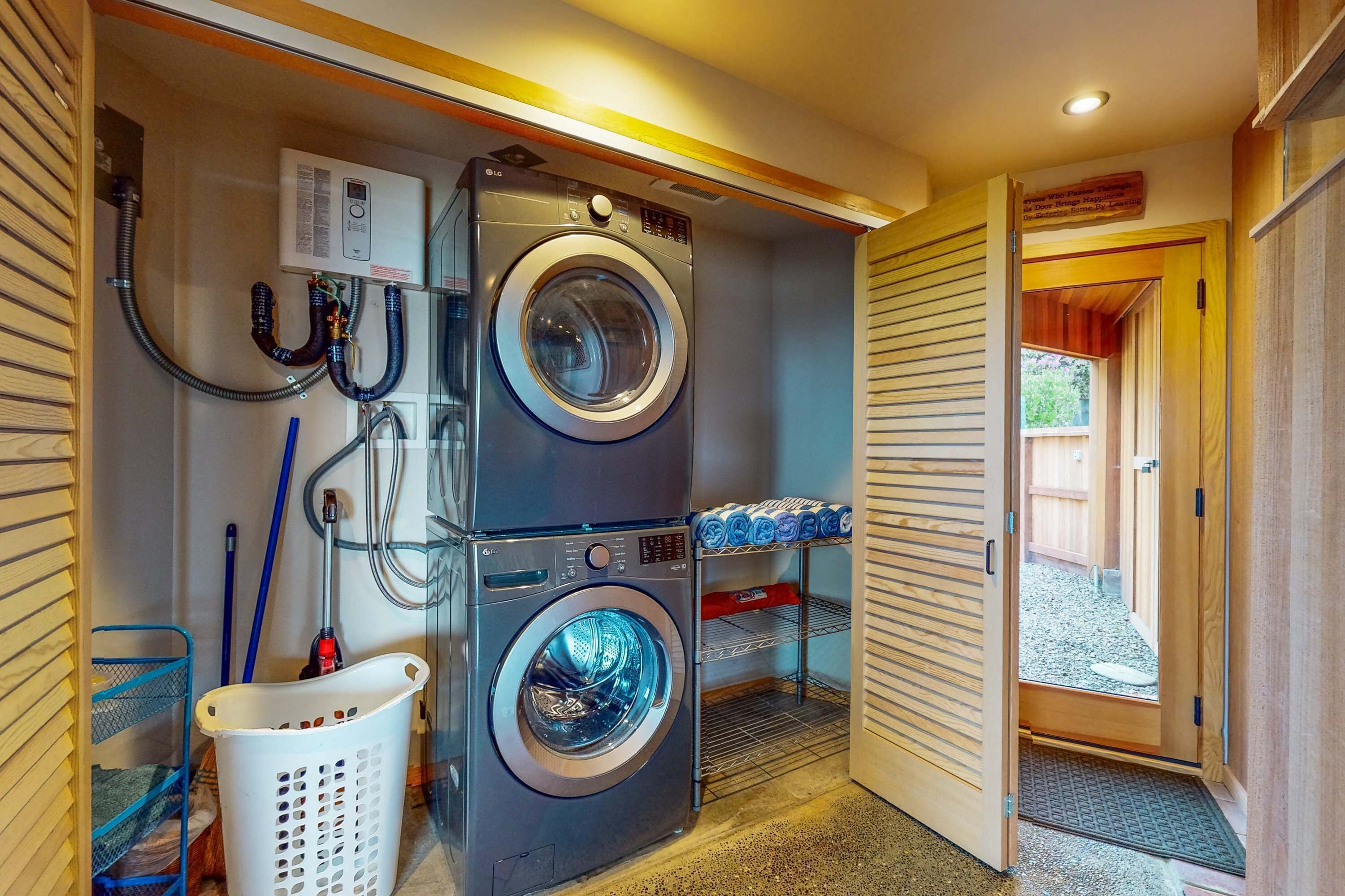 A laundry room with a front-loading washer and dryer, a utility room with a heater, and a door leading to an outdoor area.