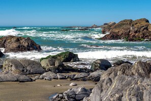 Una playa rocosa con olas rompiendo en la orilla.