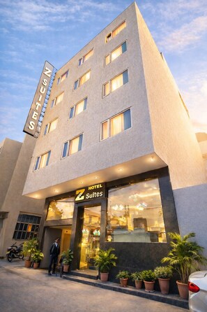 A hotel building with a sign reading 'HOTEL SUITES' and a person standing at the entrance. - Z Premium Suites -Near IGI Delhi Airport (New Delhi)