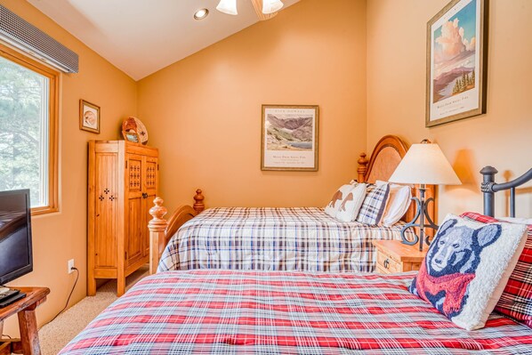 A bedroom with two beds, a wooden cabinet, a television, and a framed picture on the wall. - Merz Mountain Hideaway - Mtn Views & Private Deck (Angel Fire)