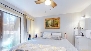 Une chambre à coucher avec un lit, un tableau, une fenêtre avec des rideaux, une table de chevet et une commode.
