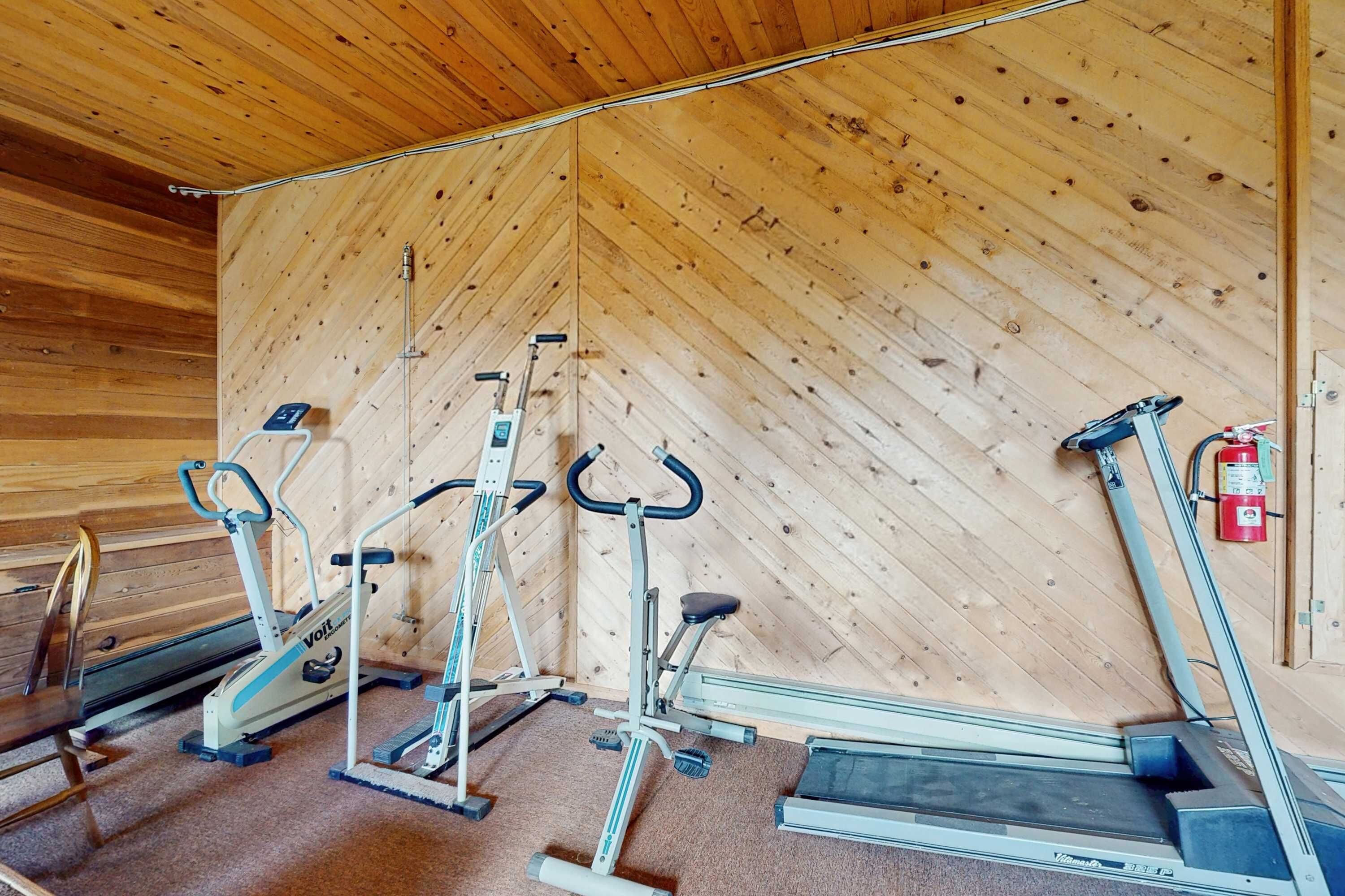 A gym with stationary bikes, ellipticals, and a treadmill.