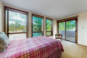 A bedroom with a large bed, multiple windows, and a chair. - Gold Creek 208 - Walk to Lifts, Slope Views & Deck (Angel Fire)
