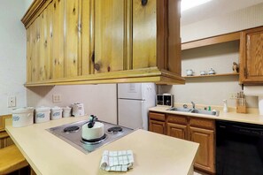 Eine Küche mit Holzausstattung, einem Herd, einem Kühlschrank, einer Spüle und einem Geschirrspüler.