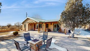 A building with a patio area featuring outdoor seating and a fire pit. - Casa de Rufina - Mountain Views, Firepit & Pets (Arroyo Seco)