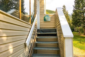 A wooden staircase leading to a building with a sign indicating sauna hours. - Sierra Del Sol 5 - Hot Tub, Walk to Lifts & Town (Taos Ski Valley)