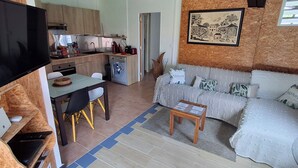 A compact living space with a kitchenette, a sofa, a TV, and a dining area. - Havre de Paix next to the coast, 5 minutes from Petit-havre beach (Le Gosier)