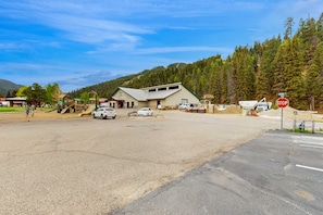 A building with a sloped roof, a stop sign, and a playground with a slide.