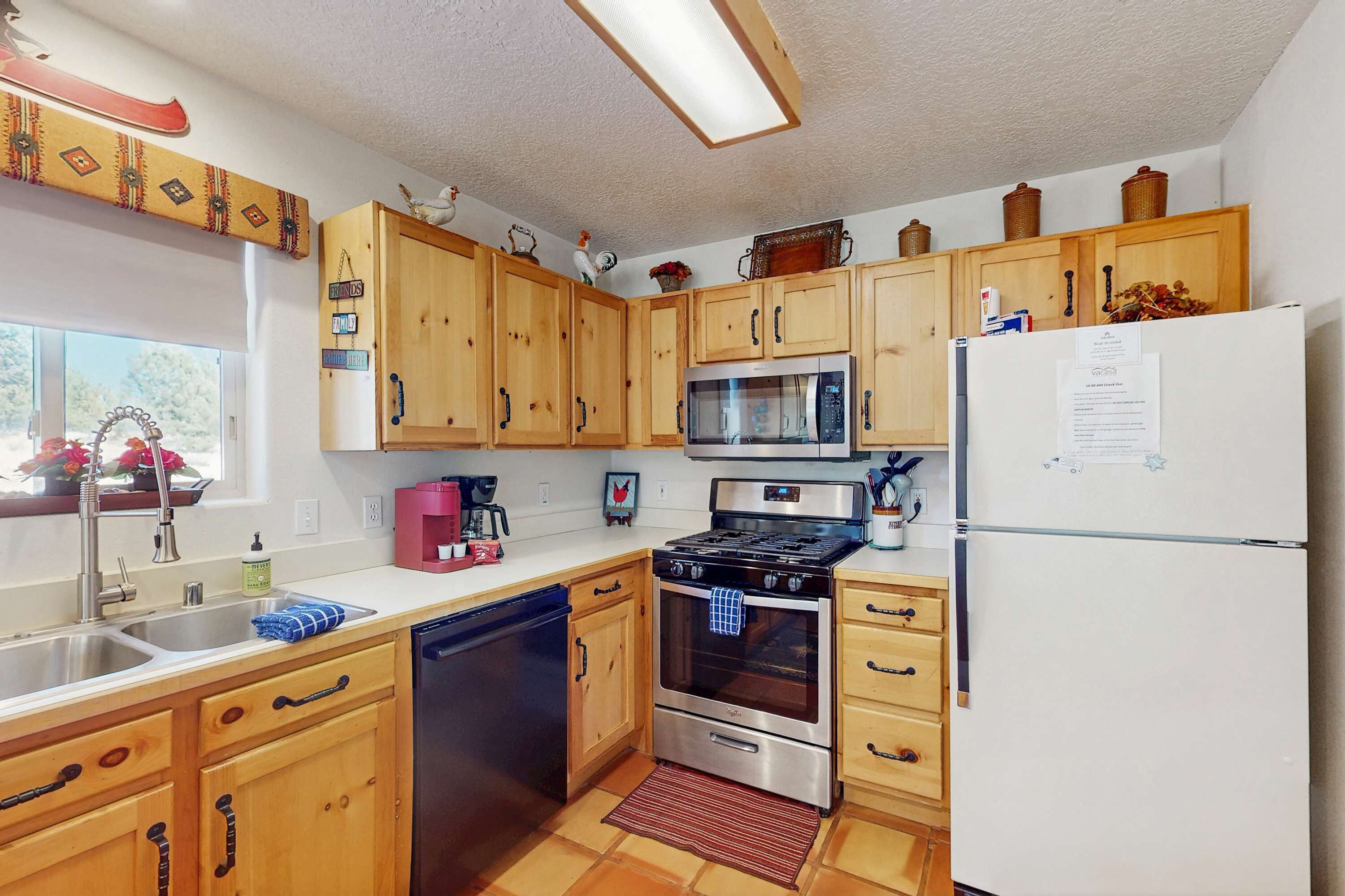 A kitchen with wooden cabinets, a stainless steel stove, a microwave, and a white refrigerator.
