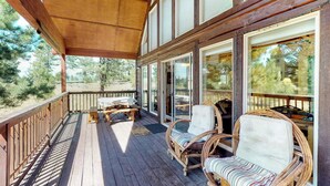A wooden deck with outdoor furniture, large windows, and a view of trees. - Painted Pony Cabin - Wraparound Deck in the Pines (Angel Fire)
