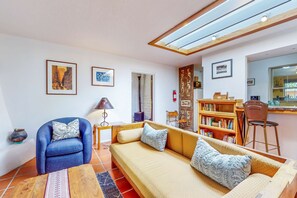 A living room with a sofa, armchair, and bookshelf. - Casa Oeste - Near Plaza with Santa Fe Charm (Santa Fe)