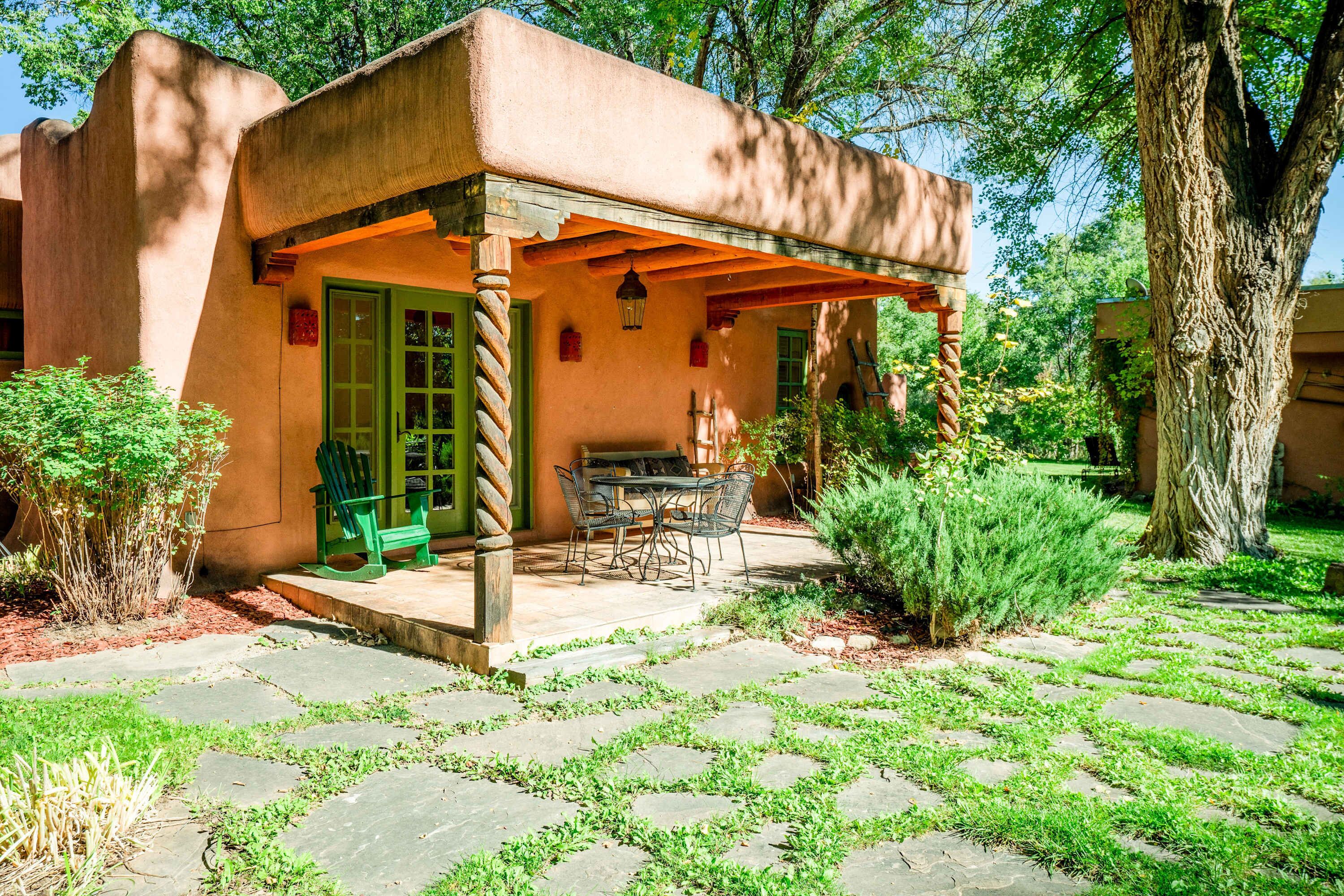 Ein rustikales Gebäude mit überdachter Terrasse, Sitzgelegenheiten im Freien und einem Kiesweg.