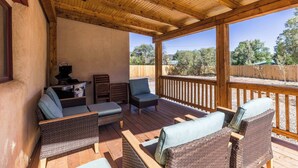 A covered outdoor patio with wicker furniture, a grill, and a view of the surrounding landscape. - Medina Casita - Mountain Views, Firepit, Pets Okay (El Prado)