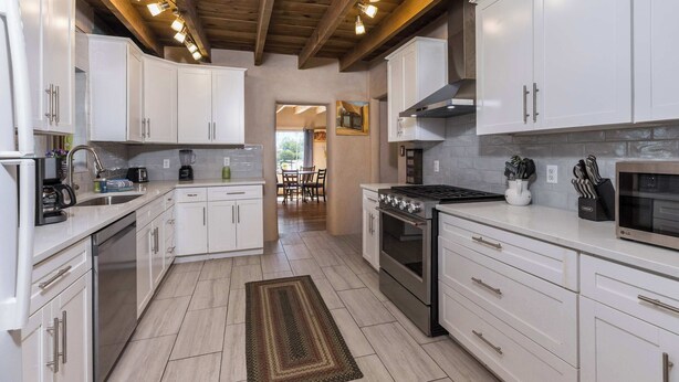 A modern kitchen with white cabinets, stainless steel appliances, and a wooden ceiling. - Medina Casita - Mountain Views, Firepit, Pets Okay (El Prado)
