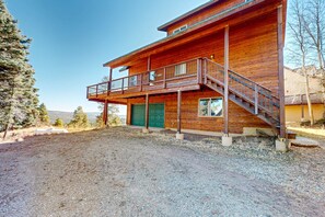 A two-story wooden cabin with a balcony, a staircase, and a gravel driveway. - Peter's Place - Panoramic Mountain Views & Decks (Angel Fire)