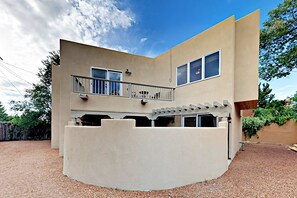 A modern two-story building with a balcony, a covered patio, and a gravel driveway. - Susan's Hideaway - Santa Fe Charm & Walk to Plaza (Santa Fe)