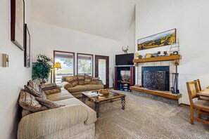Ein Wohnzimmer mit Kamin, einer Couch, einem Couchtisch und einem Essbereich.