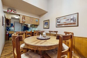 Ein Essbereich mit einem Holztisch, Stühlen und einer Küche im Hintergrund.