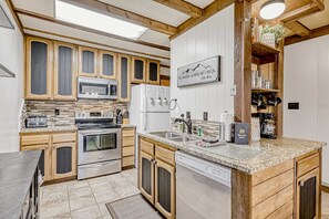 A modern kitchen with wooden cabinets, stainless steel appliances, and a granite countertop. - Timbers Townhouse 1 - Walk to Lifts, Hike & Bike (Angel Fire)