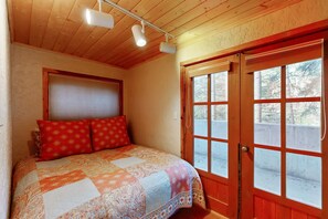 Un dormitorio con una cama, una ventana y una puerta.